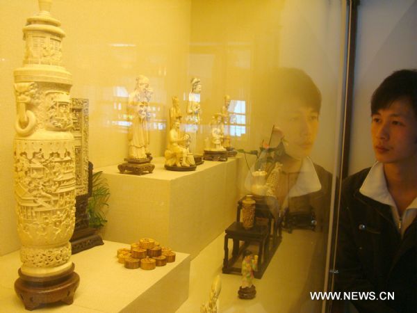 A visitor watches an ivory carving in an ivory carving show in Suzhou, east China's Jiangsu Province, April 20, 2011. The show, to be closed on May 4, showcases more than 100 ivory carvings made in China from the Ming Dynasty (1368-1644) to the 1970s. Ivory carving is the carving of animal tooth or tusk. The ancient craft has now virtually ceased, as it is illegal under most circumstances throughout the world since the Convention on International Trade in Endangered Species of Wild Fauna and Flora (CITES) in 1975. (Xinhua/Wang Jiankang) (lfj) 