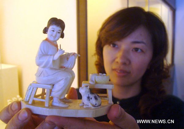 A visitor examines an ivory carving in an ivory carving show in Suzhou, east China's Jiangsu Province, April 20, 2011. The show, to be closed on May 4, showcases more than 100 ivory carvings made in China from the Ming Dynasty (1368-1644) to the 1970s. Ivory carving is the carving of animal tooth or tusk. The ancient craft has now virtually ceased, as it is illegal under most circumstances throughout the world since the Convention on International Trade in Endangered Species of Wild Fauna and Flora (CITES) in 1975. (Xinhua/Wang Jiankang) (lfj) 