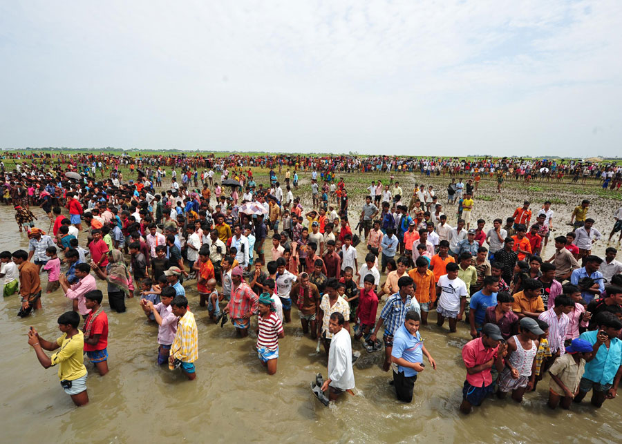 Local people wait for bodies to be salvaged from the the sunken ferry in Brahmanbaria district, Bangladesh, April 22, 2011. The death toll in a ferry capsize early Thursday in Bangladesh&apos;s Brahmanbaria district, some 109 km northeast of capital Dhaka, has risen to 33 on Friday, an official said.[Xinhua]