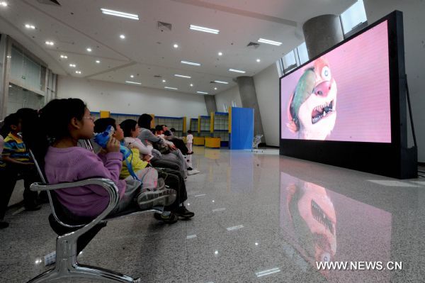 Children watch cartoon in a paradise for children in Henan Radio and Television Tower in Zhengzhou, capital of central China's Henan Province, April 23, 2011. The 388-meter-high tower, the highest in Henan Province, was open on Monday with the functions of broadcasting and sightseeing. (Xinhua/Zhu Xiang)(yrz) 