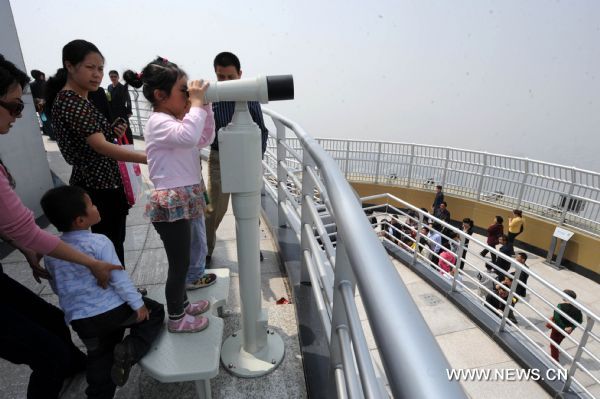  A girl does sightseeing with a telescope in Henan Radio and Television Tower in Zhengzhou, capital of central China's Henan Province, April 23, 2011. The 388-meter-high tower, the highest in Henan Province, was open on Monday with the functions of broadcasting and sightseeing. (Xinhua/Zhu Xiang)(yrz) 