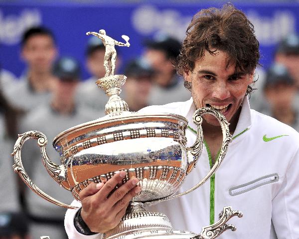 Spain's Rafael Nadal celebrates with the trophy after winning the final of the Barcelona Open tennis tournament Conde de Godo against compatriot David Ferrer in Barcelona. Nadal won 6-2, 6-4. (Xinhua/AFP Photo) 