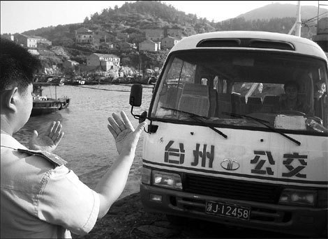 Under the direction of a local policeman, a public bus drives on to Dachendao island, off Taizhou city, in East China's Zhejiang province. Zhejiang's 12th Five-Year Plan (2011-2015) showed that the province aims to generate more than 720 billion yuan ($116 billion) in gross ocean product by the end of 2015. [China Daily]