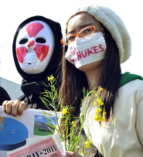 Protestors wear masks as they protest against Japan&apos;s nuclear policy during a parade for Earth Day in Tokyo on April 24, 2011.