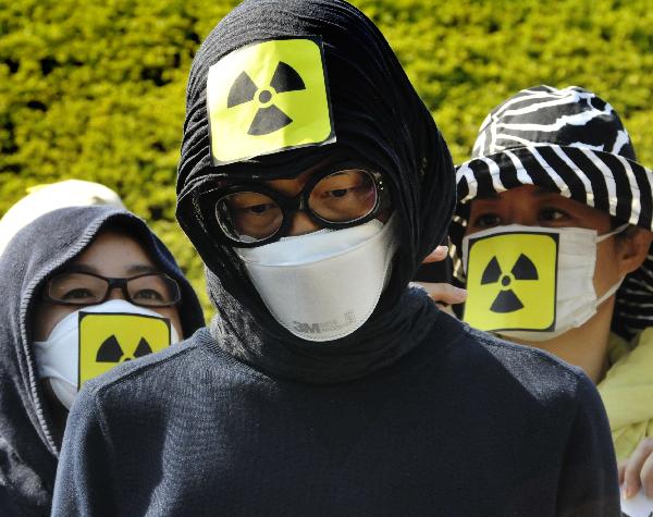 Protestors wear masks as they protest against Japan&apos;s nuclear policy during a parade for Earth Day in Tokyo on April 24, 2011. 