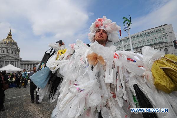 A man wears a costume made of plastic bag, symbolizing its harm to the environment, during a promotion of the Earth Day in San Francisco, the United States, April 23, 2011.