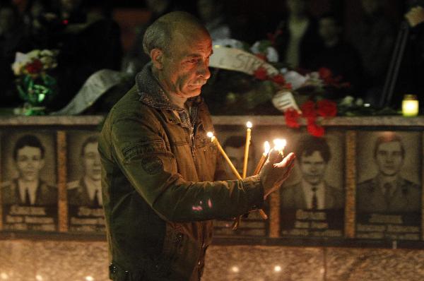 A local resident lights a candle at the Chernobyl victims' monument in Slavutich, some 50 km away from the accident's site during a memorial ceremony, on April 26. [Xinhua]