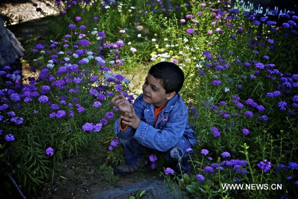 A child smells flowers at a park during the traditional festival &apos;the Day of Beneficial Wind&apos; in Cairo, Egypt, April 25, 2011. (Xinhua/Cai Yang) (xhn) 