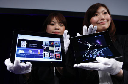 Promoters pose with Sony's first tablet PCs S1 (left) and S2 at their unveiling ceremony in Tokyo yesterday. Sony, a laggard in the booming tablet market, launched its first tablet computers in an ambitious attempt to grab second spot in the market created and dominated by Apple's iPad.