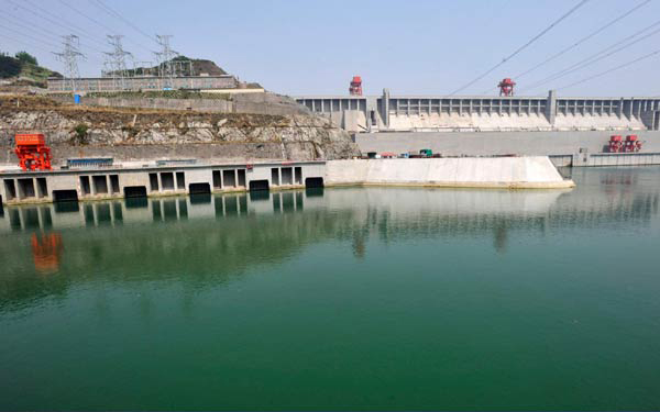 The combination of two photos ( taken on April 26, 2011 and December 1, 2010) shows the outside of the underground powerhouse of the Three Gorges in Yichang, Central China's Hubei province. [Photo/Xinhua]