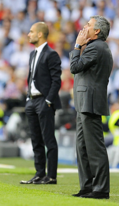 Real Madrid's coach Jose Mourinho (R) reacts in front of Barcelona's coach Pep Guardiola during their Champions League semi-final first leg soccer match at Santiago Bernabeu stadium in Madrid, April 27, 2011. (Xinhua/Reuters Photo)