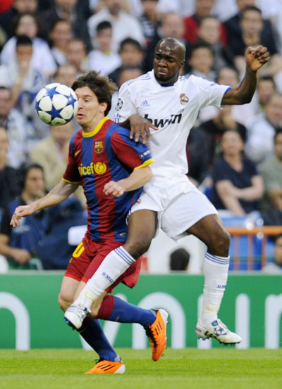 Real Madrid's Lassana Diarra (R) challenges Barcelona's Lionel Messi during their Champions League semi-final first leg soccer match at Santiago Bernabeu stadium in Madrid April 27, 2011. (Xinhua/Reuters Photo)