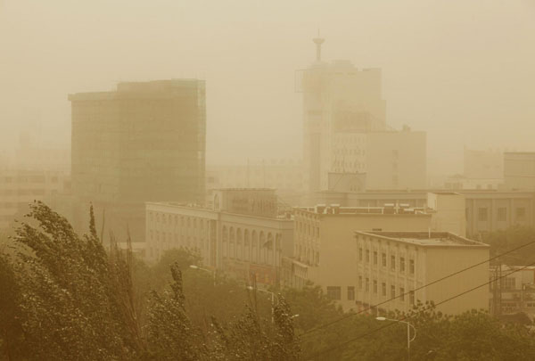 Buildings are shrouded in sand and dust in Turpan in the Xinjiang Uygur autonomous region, April 28, 2011. A cold front whipped up sandstorms in Turpan city, lowering visibility to less than 30 meters. [Xinhua]