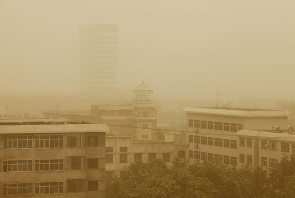 Buildings are shrouded in sand and dust in Turpan in the Xinjiang Uygur autonomous region, April 28, 2011.