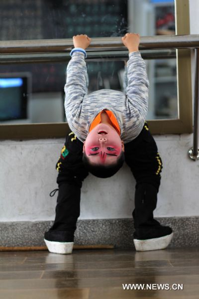 Cheng Bin makes a backward bend during a Peking Opera training session in Nantong, east China's Jiangsu Province, April 16, 2011. The ten-year-old Cheng Bin is a pupil of the Chenqiao Primary School, a small rural school in Nantong. He and some 200 pupils of the school started to learn Peking Opera when they are in the first grade. When attired in various costumes, moving with agility in thick-soled performance boots and colored greasepaint on his face, Cheng becomes a powerful 'magnet' that attracts the audience. Despite his increasing popularity among the audience in east China's Jiangsu Province where he was born, the chubby boy has his vexations, not least his 37.5-kg body weight which is unbecoming to his age and his 1.29-meter height. In the eyes of others, Cheng Bin is a lovable Humpty-Dumpty. However, obesity has posed an obstacle in his pursuit of becoming a professional Peking Opera actor. Each time when he attended Peking Opera course in which action trainings were given, Cheng would have to make greater efforts than his fellows. During a training session which usually involved rolling, jumping, kneeling and doing horizontal splits, Cheng would be soaked in sweat two or three times. 'The boy has a talent for stage performance, good understanding of the characters and fine vocal conditions. He will have better career prospect if he loses weight,' says Li Pengshan, a famous actor who chose Cheng as his disciple when the kindergarten boy's performance impressed him in 2006. With the possibility of failing to realize his dream looming large, Cheng made up his mind to battle against obesity and a series of tough moves have been taken since April. He went on diet and gave up greasy and spicy dishes he used to love; he walked four kilometers to school and back home each day; and he did various physical exercises after school. Cheng's mother is a worker in a brewery in Nantong and his father works for a local construction company. In March of last year, the couple planed to break off their son's Peking Opera course, which are in conflict with his primary school education. But they eventually changed their mind. 'We are really thankful to the instructors who devoted so much to our son and we are also touched by our son's determination,' says Yang Lihong, Cheng's mother. 'The best we can do is to offer full support.' 'If you want to achieve something, you must first conquer yourself.' The line from the film 'Farewell My Concubine' is Cheng's motto. Last August, Cheng was awarded second prize in a provincial children's Peking Opera competition in Jiangsu after beating over 300 competitors. In May, 2011, he will be taking part in a national-level children's Peking Opera competition held in Nanjing, capital of east China's Jiangsu Province. (Xinhua/Huang Zhe) (ljh) 