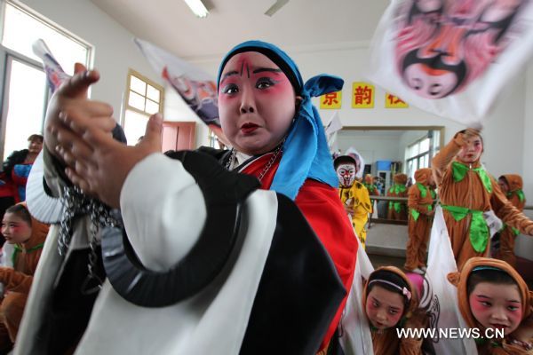 Cheng Bin (Front) undertakes an improvised performance during a Peking Opera training session in Nantong, east China's Jiangsu Province, April 16, 2011. The ten-year-old Cheng Bin is a pupil of the Chenqiao Primary School, a small rural school in Nantong. He and some 200 pupils of the school started to learn Peking Opera when they are in the first grade. When attired in various costumes, moving with agility in thick-soled performance boots and colored greasepaint on his face, Cheng becomes a powerful 'magnet' that attracts the audience. Despite his increasing popularity among the audience in east China's Jiangsu Province where he was born, the chubby boy has his vexations, not least his 37.5-kg body weight which is unbecoming to his age and his 1.29-meter height. In the eyes of others, Cheng Bin is a lovable Humpty-Dumpty. However, obesity has posed an obstacle in his pursuit of becoming a professional Peking Opera actor. Each time when he attended Peking Opera course in which action trainings were given, Cheng would have to make greater efforts than his fellows. During a training session which usually involved rolling, jumping, kneeling and doing horizontal splits, Cheng would be soaked in sweat two or three times. 'The boy has a talent for stage performance, good understanding of the characters and fine vocal conditions. He will have better career prospect if he loses weight,' says Li Pengshan, a famous actor who chose Cheng as his disciple when the kindergarten boy's performance impressed him in 2006. With the possibility of failing to realize his dream looming large, Cheng made up his mind to battle against obesity and a series of tough moves have been taken since April. He went on diet and gave up greasy and spicy dishes he used to love; he walked four kilometers to school and back home each day; and he did various physical exercises after school. Cheng's mother is a worker in a brewery in Nantong and his father works for a local construction company. In March of last year, the couple planed to break off their son's Peking Opera course, which are in conflict with his primary school education. But they eventually changed their mind. 'We are really thankful to the instructors who devoted so much to our son and we are also touched by our son's determination,' says Yang Lihong, Cheng's mother. 'The best we can do is to offer full support.' 'If you want to achieve something, you must first conquer yourself.' The line from the film 'Farewell My Concubine' is Cheng's motto. Last August, Cheng was awarded second prize in a provincial children's Peking Opera competition in Jiangsu after beating over 300 competitors. In May, 2011, he will be taking part in a national-level children's Peking Opera competition held in Nanjing, capital of east China's Jiangsu Province. (Xinhua/Huang Zhe) (ljh) 