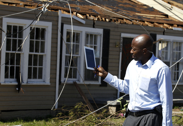 U.S. President Barack Obama's assistant Reggie Love takes video using his iPad 2 of damage caused by devastating severe storms and tornadoes in the Tuscaloosa, Alabama April 29, 2011. [Xinhua/Reuters Photo]