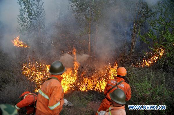 Firefighters hose down fire in a forest that borders the cities of Jingzhong and Yangquan, north China&apos;s Shanxi Province, April 30, 2011. The fire started at about 9 p.m. on Friday. No casualties have been reported as of Saturday noon. The battle against the blaze is still underway. [Xinhua] 