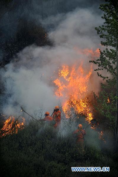 Firefighters extinguish fire in a forest that borders the cities of Jingzhong and Yangquan, north China&apos;s Shanxi Province, April 30, 2011. The fire started at about 9 p.m. on Friday. No casualties have been reported as of Saturday noon. The battle against the blaze is still underway. 