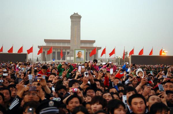  People watch flag raising at the Tiananmen Square in Beijing, capital of China, May 1, 2011. More than ten thousand people watched flagraising ceremony at the Tiananmen Square to celebrate May Day. [Xinhua]