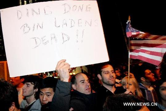 A man holds a placard reading 'Ding Dong Bin Laden's Dead!!' during a rally near the World Trade Center site celebrating the announcement of the death of Osama bin Laden in New York, the United States, May 2, 2011. [Xinhua]
