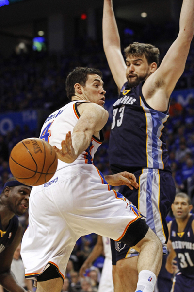 Oklahoma City Thunder forward Nick Collison (4) makes a pass behind his back as he is blocked in the lane by Memphis Grizzlies' guard Marc Gasol (33) of Spain during the second half of Game 1 of the second round of the Western Conference NBA basketball playoffs in Oklahoma City, Oklahoma, May 1, 2011. (Xinhua/Reuters Photo) 