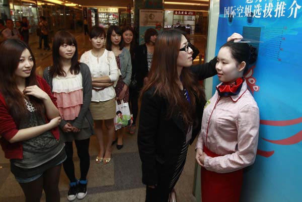 A woman measures a contestant's height in Shanghai on May 2, 2011. [Photo/Xinhua]