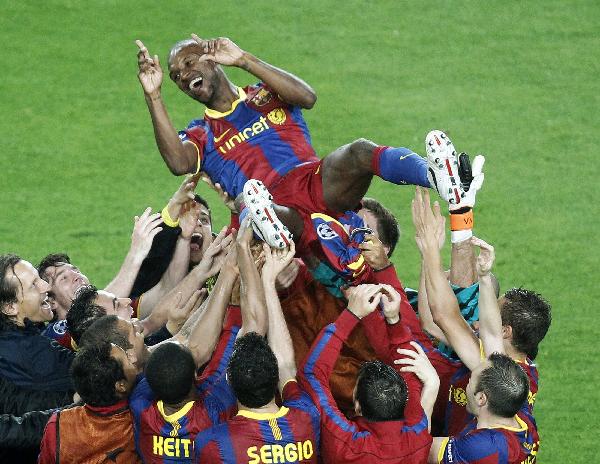 Barcelona's players throw team-mate Eric Abidal (top) in the air as they celebrate beating Real Madrid to qualify for the final during their Champions League semi-final second leg soccer match at Nou Camp stadium in Barcelona, May 3, 2011.(Xinhua/Reuters Photo)