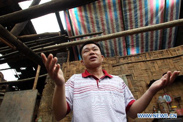 A villager describes the heavy rainstorm that hit the Changmei County on Monday afternoon, southwest China&apos;s Guangxi Zhuang Autonomous Region, May 3, 2011. A heavy rainstorm hit the county on Monday afternoon, causing 200 houses damaged but no casualties. (Xinhua