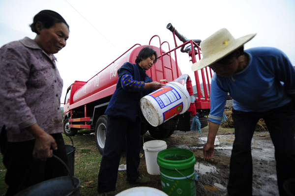 Villagers fetch drinking water dispatched by firefighting vehicles in Xiaohe township of Xiaochang county, Hubei province, May 3, 2011. [Xinhua] 