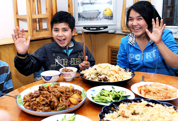 Arkbel Usuf and another Uygur girl are ready to enjoy their dinner at the Urumqi SOS Children's Village in the Xinjiang Uygur autonomous region on Monday.