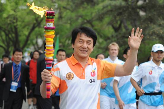 Torchbearer Jacky Chan runs with the torch during the torch relay for the 26th Summer Universiade at Shenzhen, south China's Guangdong Province, on May 4, 2011.