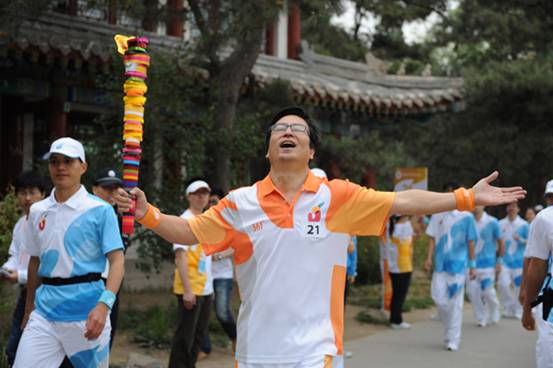 Torchbearer Bai Yansong runs with the torch during the torch relay for the 26th Summer Universiade at Shenzhen, south China's Guangdong Province, on May 4, 2011.