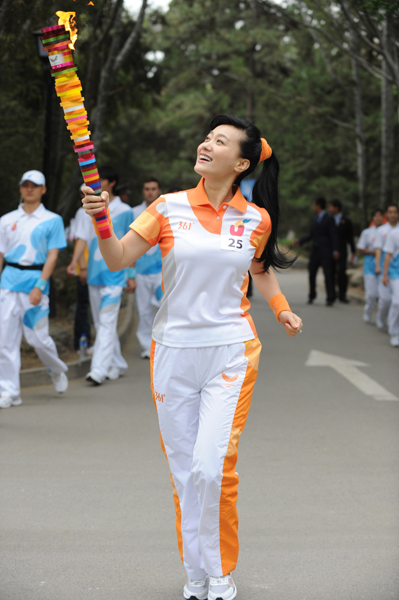 Torchbearer Tan Jing runs with the torch during the torch relay for the 26th Summer Universiade at Shenzhen, south China's Guangdong Province, on May 4, 2011. 