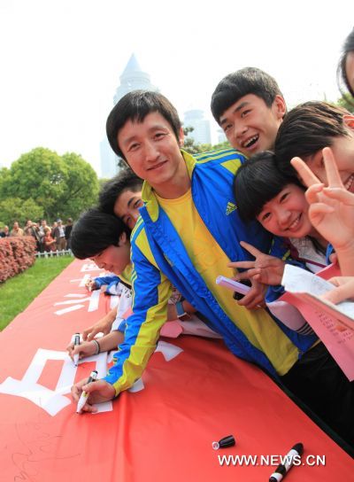 Olympic champion Zou Shiming (C) joins in the students to sign their names on a red banner during an adult ceremony in Guiyang, capital of southwest China's Guizhou Province, May 4, 2011, the Chinese Youth Day. (Xinhua/Yi Qiong) (hdt) 