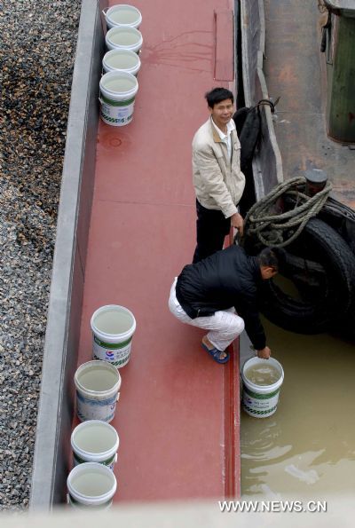 People on the detained boats collect water from the river for daily use along the Dongtiaoxi navigation channel in Huzhou City, east China&apos;s Zhejiang Province, May 4, 2011. The lower water level than normal years has caused a backup of traffic in waterway here. Since April 30, more than 700 boats have been struck here. (Xinhua/Zhou Yushun) (lfj) 