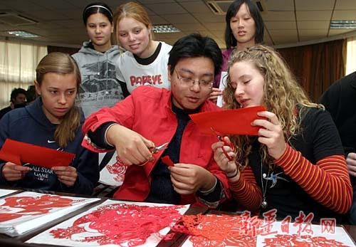 A file photo show foreign students learn traditional Chinese paper-cutting art. The number of people around the world learning Chinese has passed 40 million globally. 