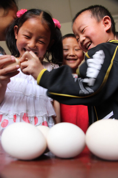 Children have a cracking time of egg fighting in Xichating village of Shiyan city in central China's Hubei Province, May 6, 2011, the day of summer begins (立夏). Many people in China boil an egg to take part in the tradition of egg fighting which heralds the start of summer in the Chinese lunar calendar, marking the transition of seasons.