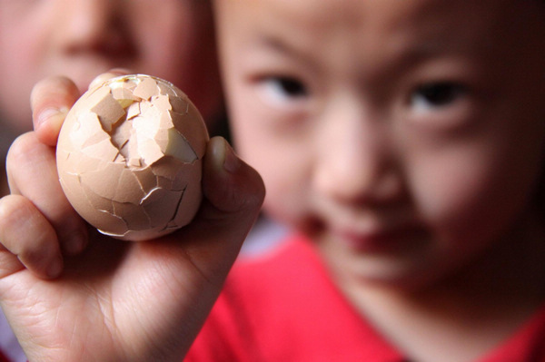 Children have a cracking time of egg fighting in Xichating village of Shiyan city in central China's Hubei Province, May 6, 2011, the day of summer begins (立夏). Many people in China boil an egg to take part in the tradition of egg fighting which heralds the start of summer in the Chinese lunar calendar, marking the transition of seasons. 