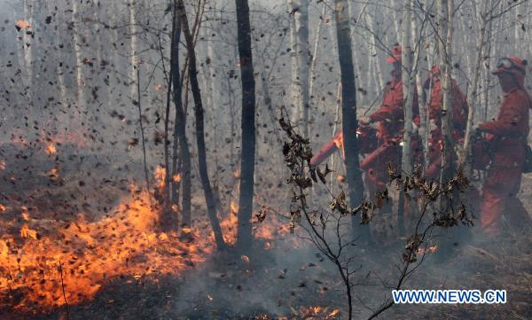 Firefighters work to control a forest fire in Jiayin County of Yichun, northeast China&apos;s Heilongjiang Province, May 5, 2011.