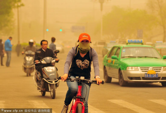 People struggle to make their way home amid the strong sandstorm that hit Northwest China's Gansu Province Thursday, April 28, 2011. [CFP] 