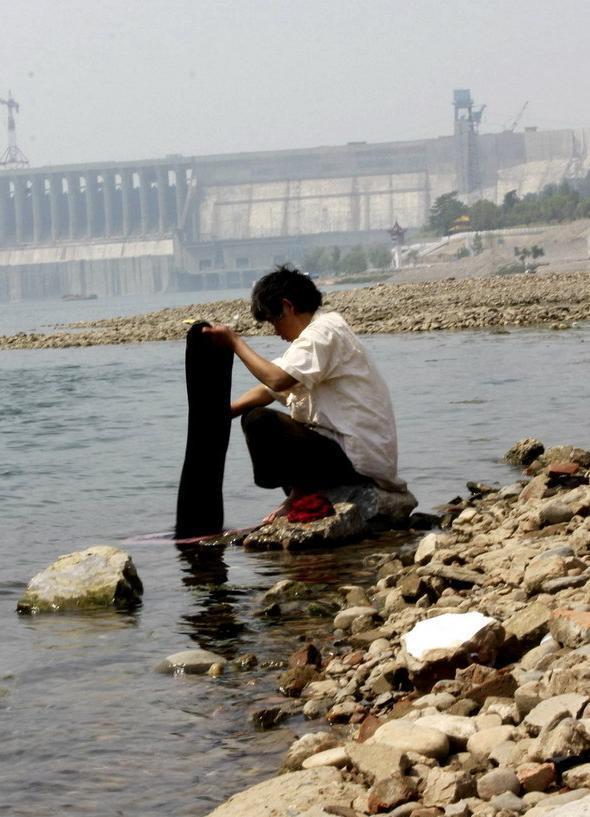 A man washes clothes at riverside in Danjiangkou Reservoir in central China's Hubei Province, May 5, 2011. 