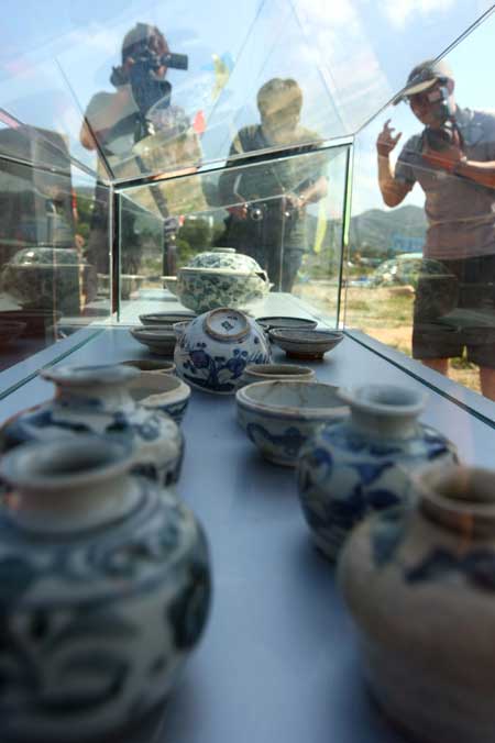 Archaeologists examine ancient porcelain wares that were excavated from the submarine cultural relic site of the Nan'ao-I in Shantou, Guangdong Province on September 26, 2009. 
