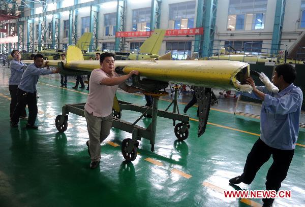 Workers move wings at the K8 trainers assembly plant of Hongdu Aviation Industry Group in Nanchang, capital of East China's Jiangxi province, April 26, 2011.