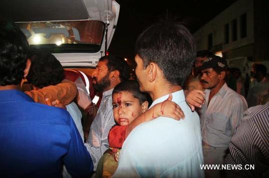 A man carries an injured child outside a hospital in southern Pakistani port city of Karachi, May 6, 2011. At least five people were killed and 18 others injured in a blast that took place Friday night in Karachi, the largest industrial city in Pakistan, reported local Urdu TV channel News 5. [Arshad/Xinhua]