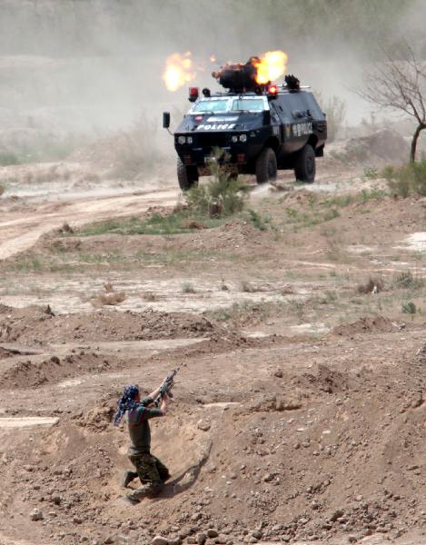 An armed vehicle fires during joint anti-terror drill in Kaxgar, northwest China's Xinjiang Uygur Autonomous Region, May 6, 2011. China, Kyrgyzstan and Tajikistan, all member states of the Shanghai Cooperation Organization (SCO), Friday conducted a joint anti-terror drill in Xinjiang, according to a statement issued by China's Ministry of Public Security. 