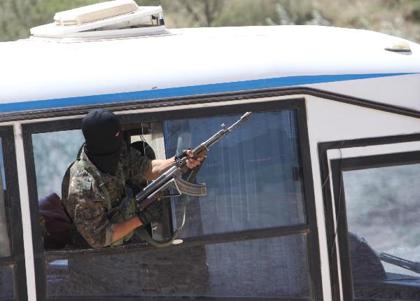 A 'terrorist' shoots during a joint anti-terror drill in Kaxgar, northwest China's Xinjiang Uygur Autonomous Region, May 6, 2011. China, Kyrgyzstan and Tajikistan, all member states of the Shanghai Cooperation Organization (SCO), Friday conducted a joint anti-terror drill in Xinjiang, according to a statement issued by China's Ministry of Public Security. 