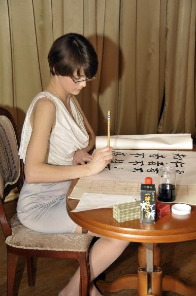 A contestant presents her talent for Chinese calligraphy during the final of the 10th 'Chinese Bridge' Chinese Proficiency Competition for Foreign College Students in Moscow, capital of Russia, on May 6, 2011. The 10th 'Chinese Bridge' Chinese Proficiency Competition for Foreign College Students in Moscow concluded here Friday. [Zhao Danwen/Xinhua]