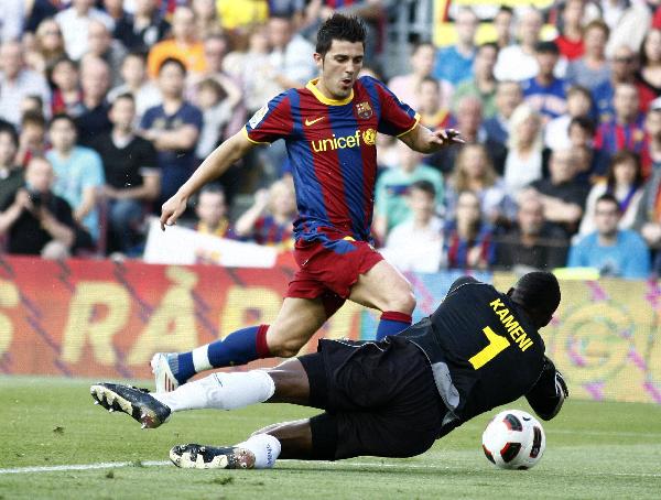 Barcelona's David Villa runs for the ball against Espanyol goalkeeper Kameini during their Spanish first division soccer match at Nou Camp stadium in Barcelona May 8, 2011. (Xinhua/Reuters Photo) 