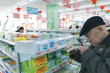 A customer studies the labels on medicine at a drug store in Dandong, Liaoning province.[China Daily]